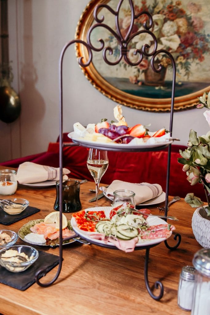 Frühstückstafel mit frischem Obst und herzhaftem Fingerfood in stilvollem Ambiente.