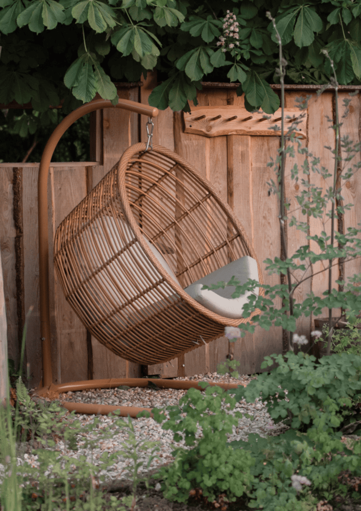Entspannender Gartenhängesessel aus Rattan in natürlichem Design.