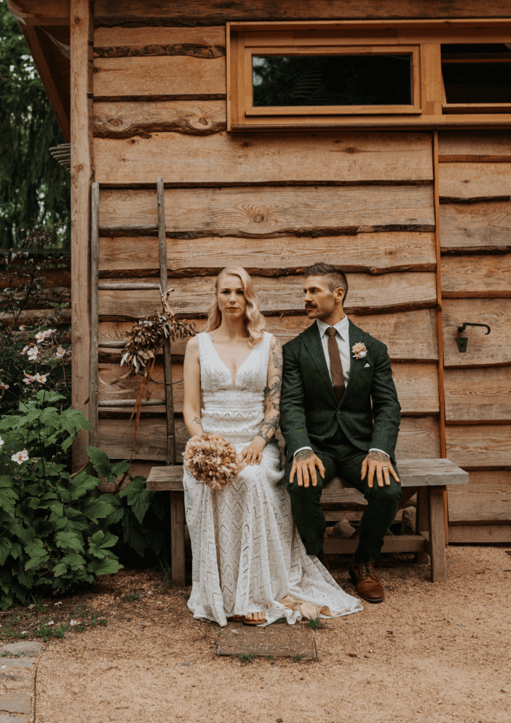 1. Rustikale Hochzeitskleidung vor Holzhaus bei Gut Leben Berlin.