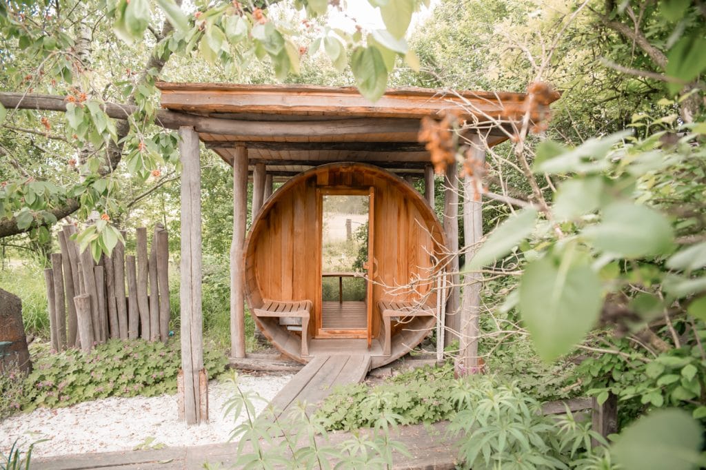 Holzsauna im grünen Garten, nachhaltiges Wohlbefinden, entspannende Wellnessoase in Berlin.