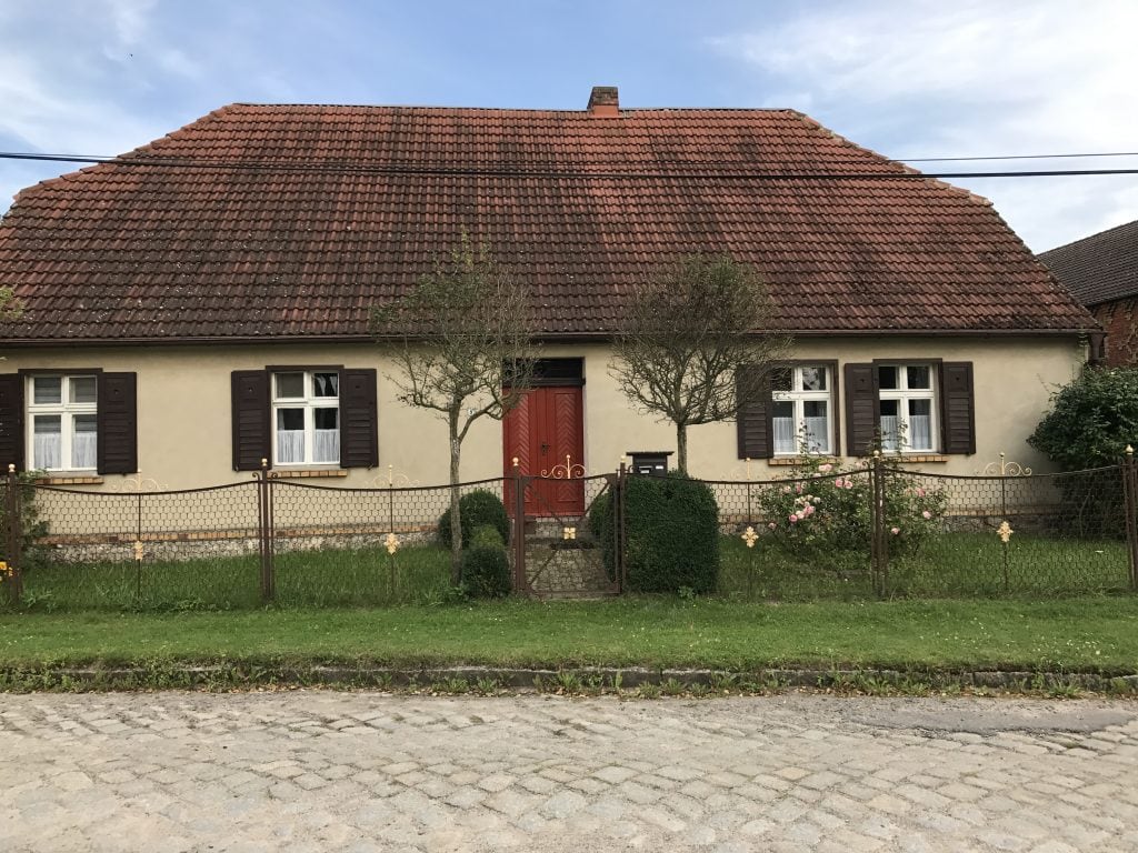 Gemütliches Haus mit traditionellem roten Ziegeldach und gepflegtem Garten in Berlin.