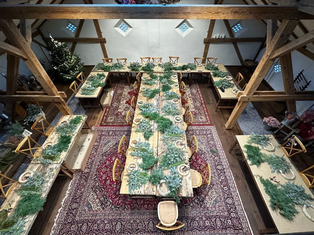 Festlich dekorierter Wintergarten mit rustikalem Holztisch und grüner Accessoires-Dekoration.