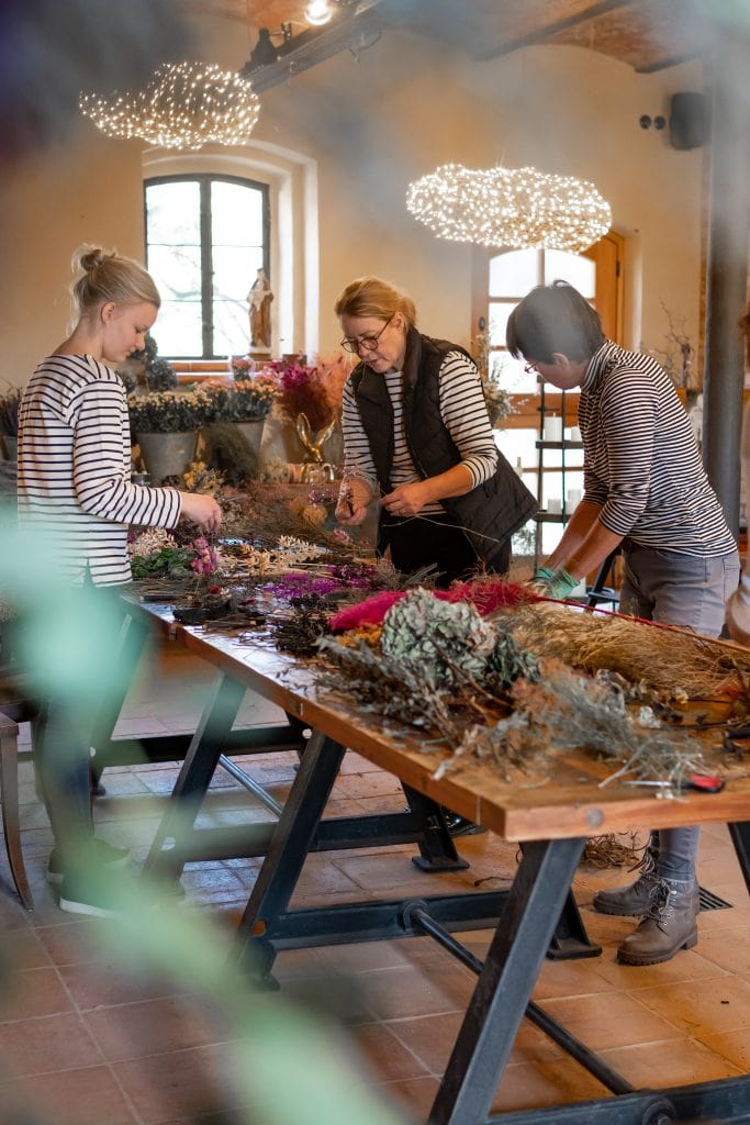 - Frische Kräuter und Blumen werden in einem Workshop in Berlin gebunden.