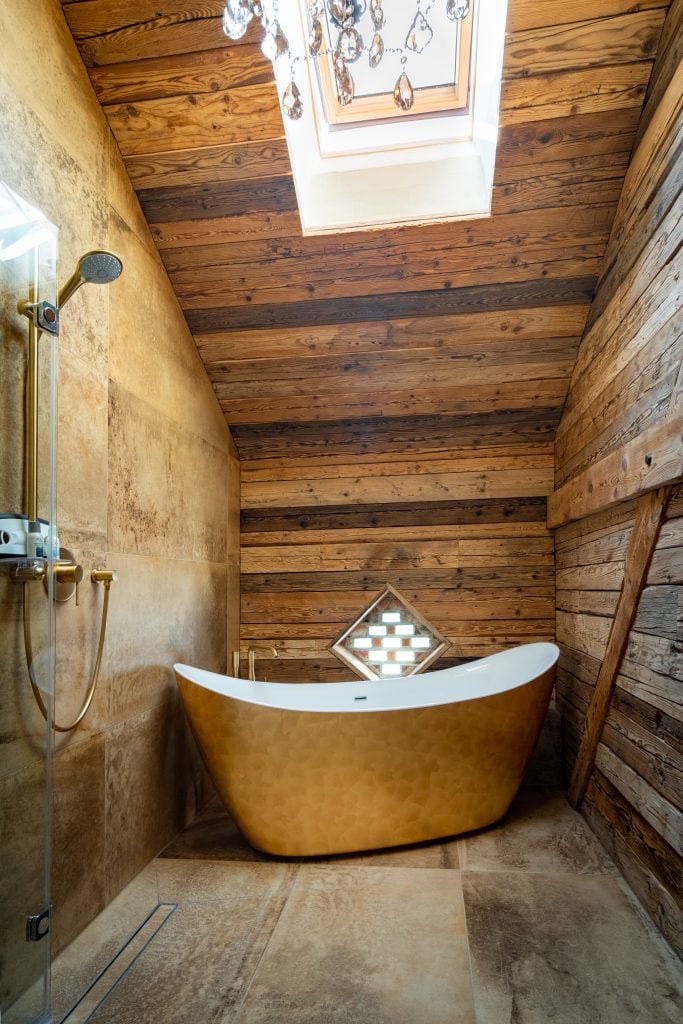 Entspannende Badewanne im Wellnessbereich mit Holzverkleidung und Dachfenster.