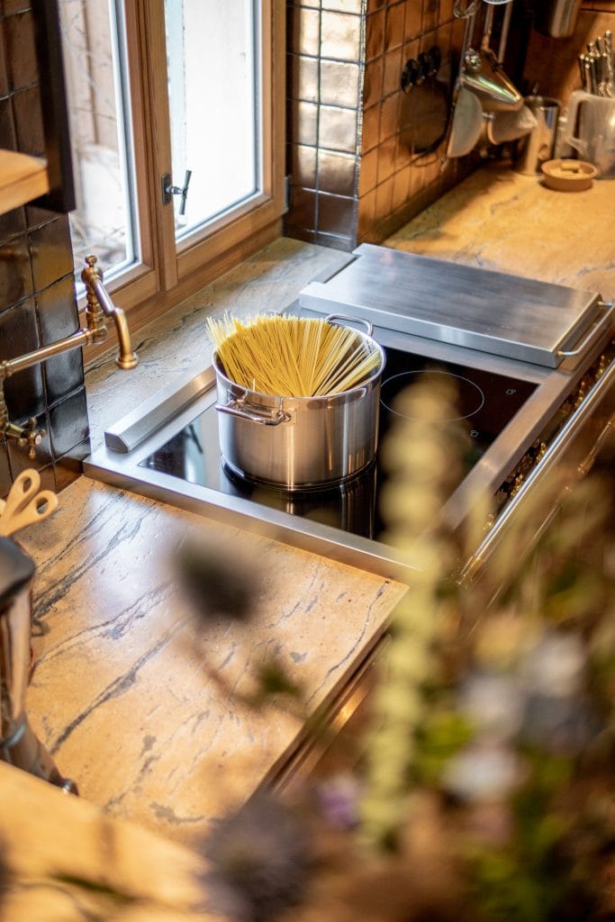 Frische Pasta in einem Topf auf einer Küche mit Holzarbeitsplatten und Kochfeld.