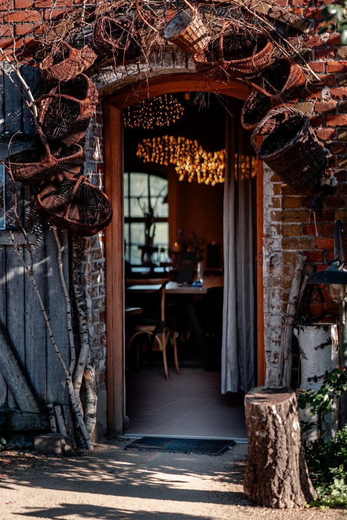 Gemütlicher Eingang eines Bio-Restaurants mit natürlichen Dekorationen und Öko-Atmosphäre, Fokus auf nachhaltiges Leben.