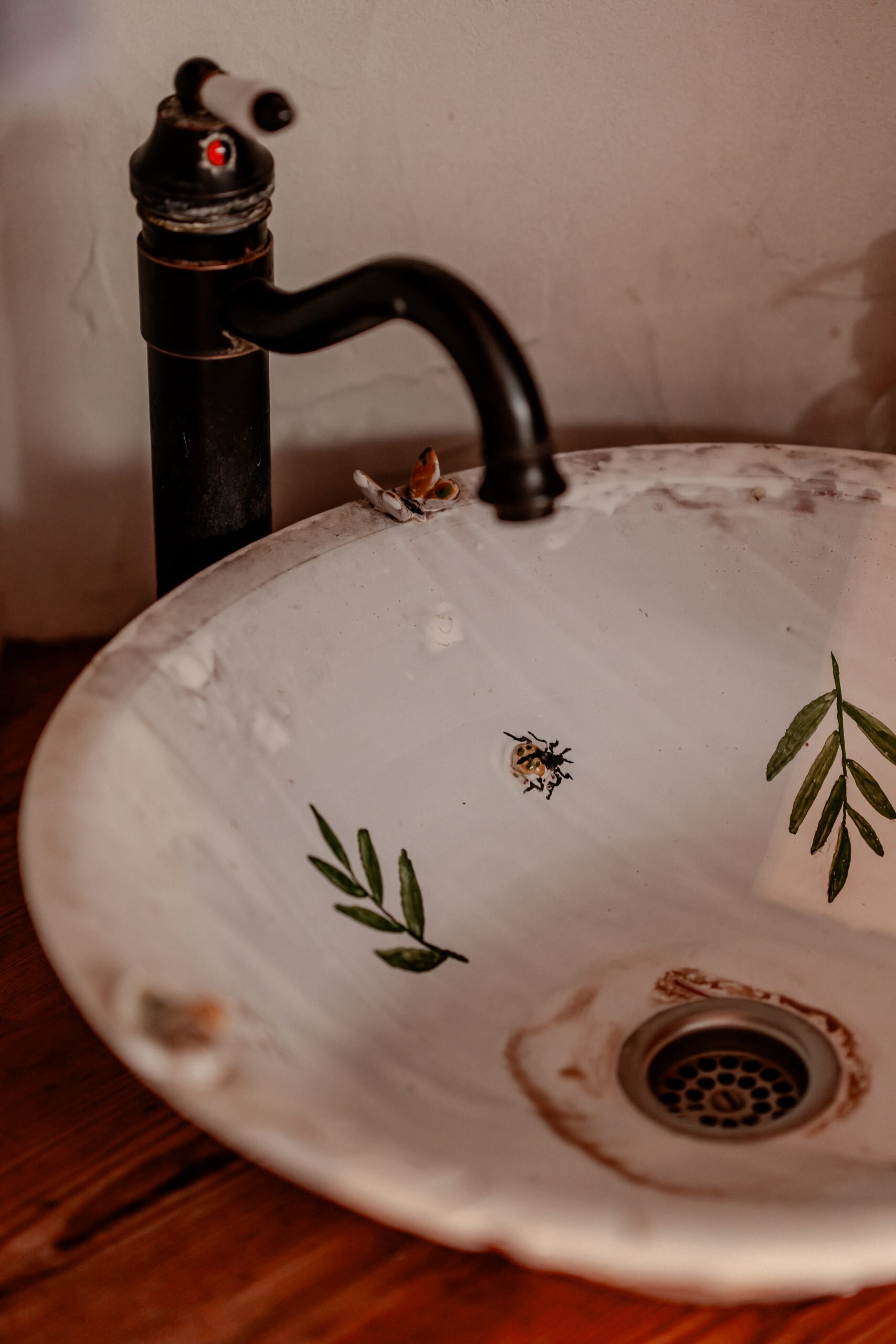 1. Waschbecken mit Pflanzen- und Insektenmotiven, nachhaltiges Wohnen, Naturverbundenheit.