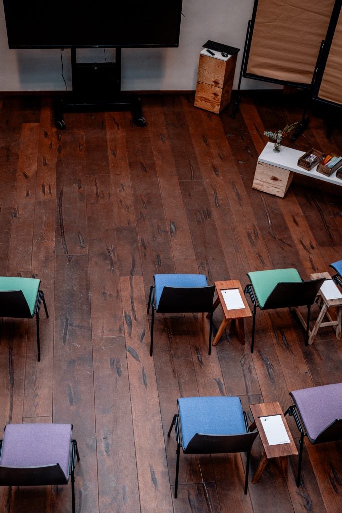 Entspannter Seminarraum mit bunten Stühlen und Holzmöbeln bei Gut Leben Berlin.