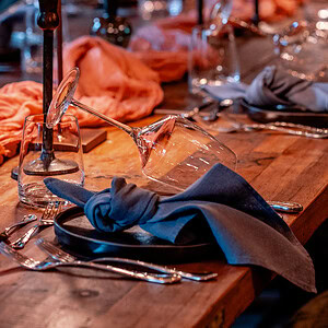 Eleganter gedeckter Tisch mit Wein und Kerzen für ein geselliges Essen, gemütliche Atmosphäre, Fokus auf Gastronomie.