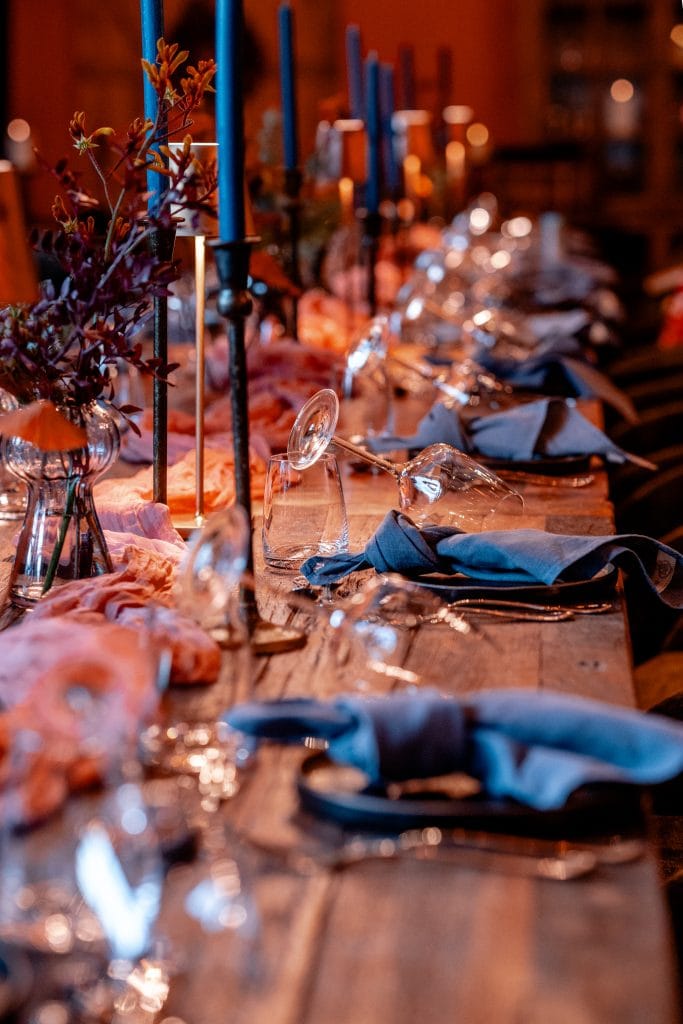 Eleganter, festlicher Esstisch mit Kerzen und Blumen für eine besondere Genuss- und Wohlfühlatmosphäre.