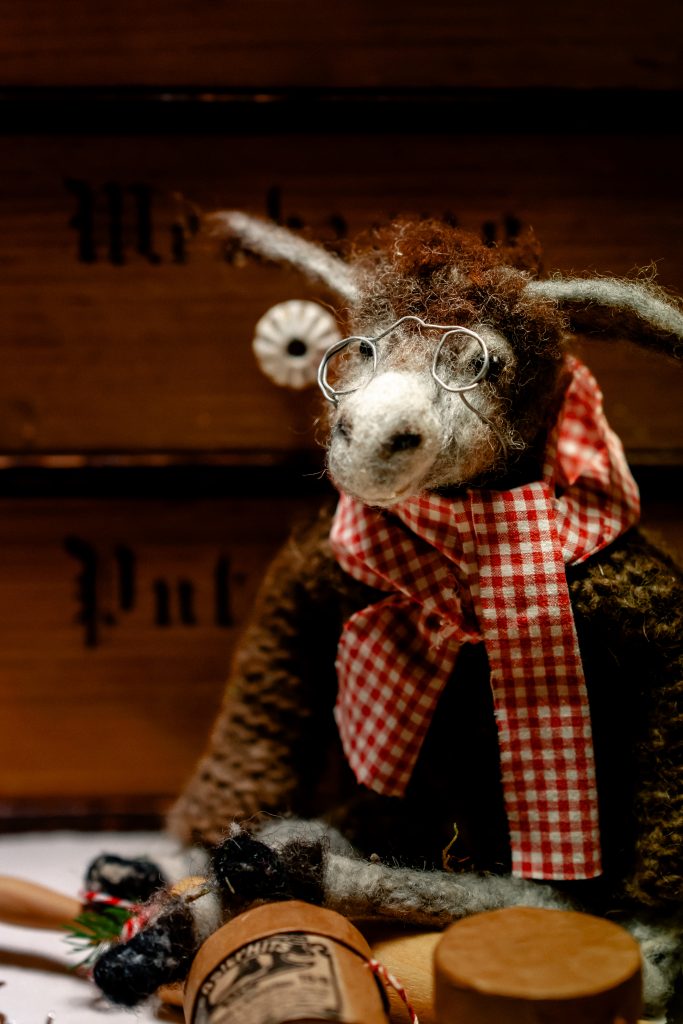 Wollierter Dackel mit Brille und Schleife, Dekoration im rustikalen Stil, für ein gemütliches Zuhause.