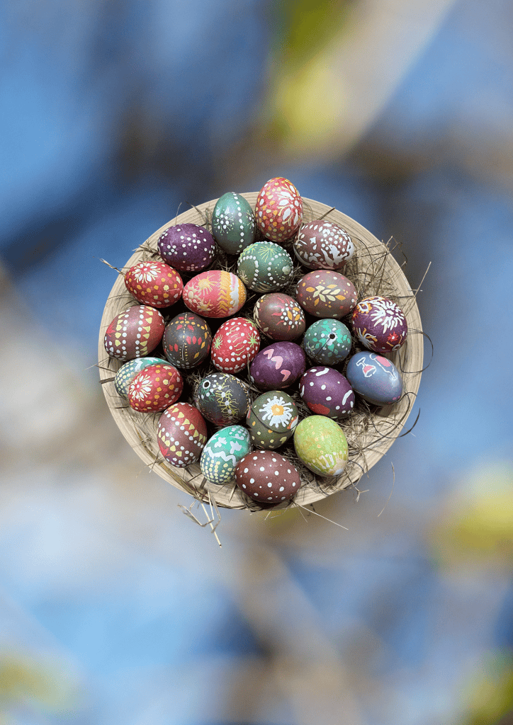 Bunte Ostereier in einem Weidenkorb, symbolisch für Frühling und Ostern in Berlin.