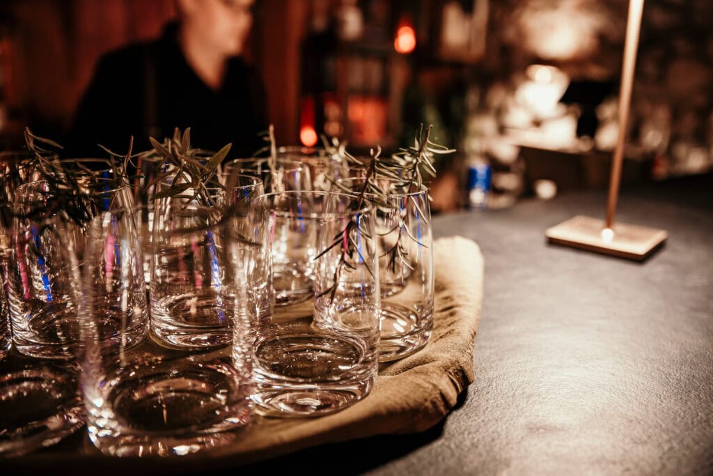 Gläser auf einer Party im dunklen, gemütlichen Ambiente bei Gut Leben Berlin.