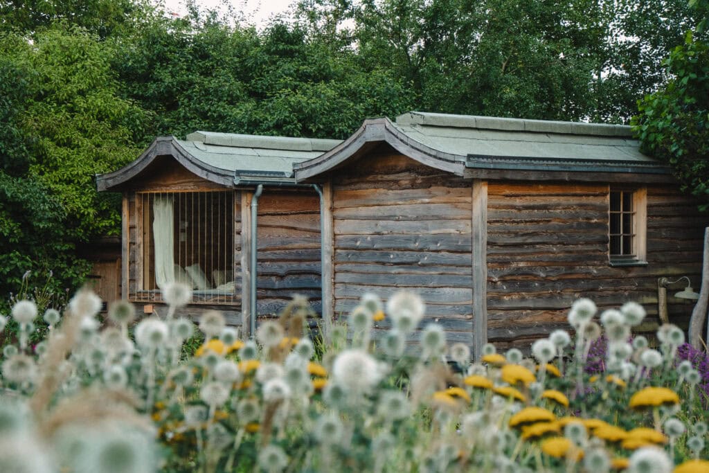 Rustikales Gartenhaus inmitten blühender Wiese bei Gut Leben.
