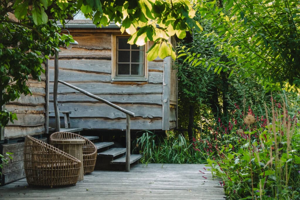 Gemütliches Holzhaus mit Garten und Sitzgelegenheiten im Grünen.