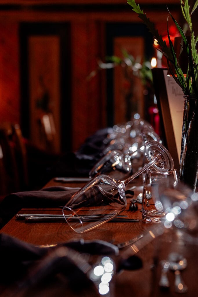 Eleganter gedeckter Tisch mit Weingläsern und Blumen bei Gut Leben Berlin.