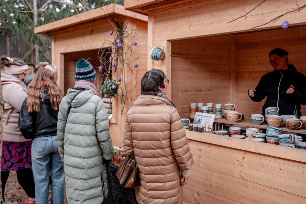 Menschen kaufen handgemachte Keramik bei Gut Leben Berlin Weihnachtsmarkt.