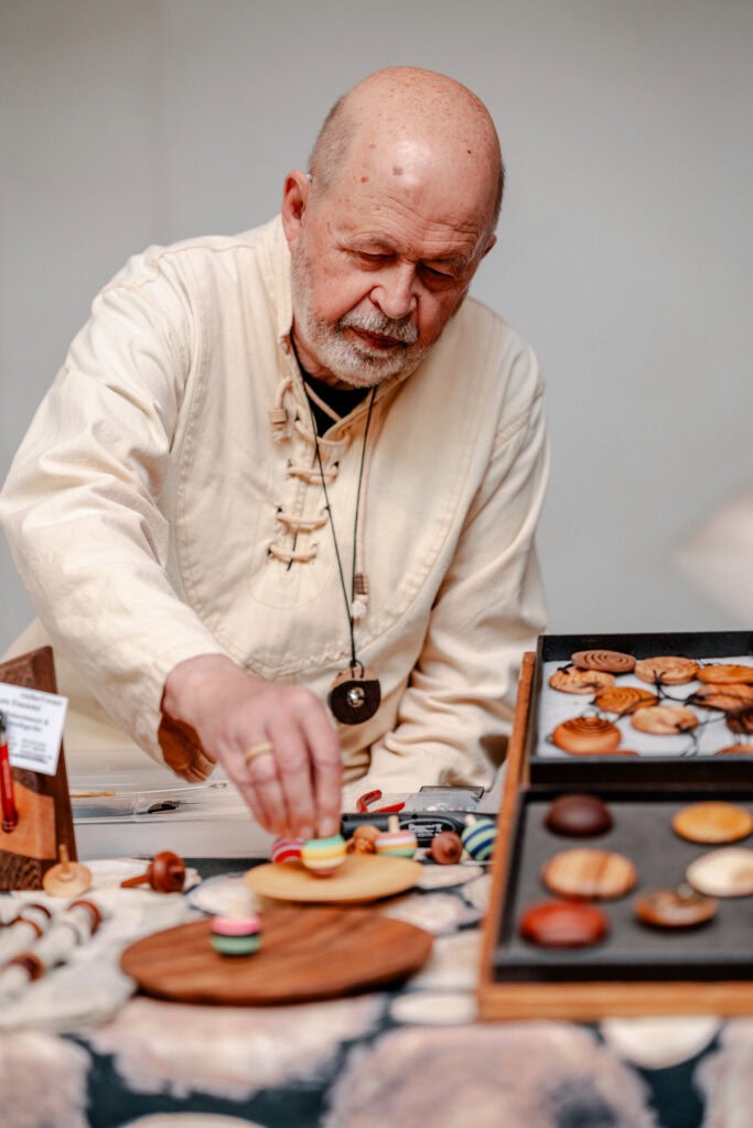 Älterer Mann beim Backen und Dekorieren von Keksen in der Bäckerei.