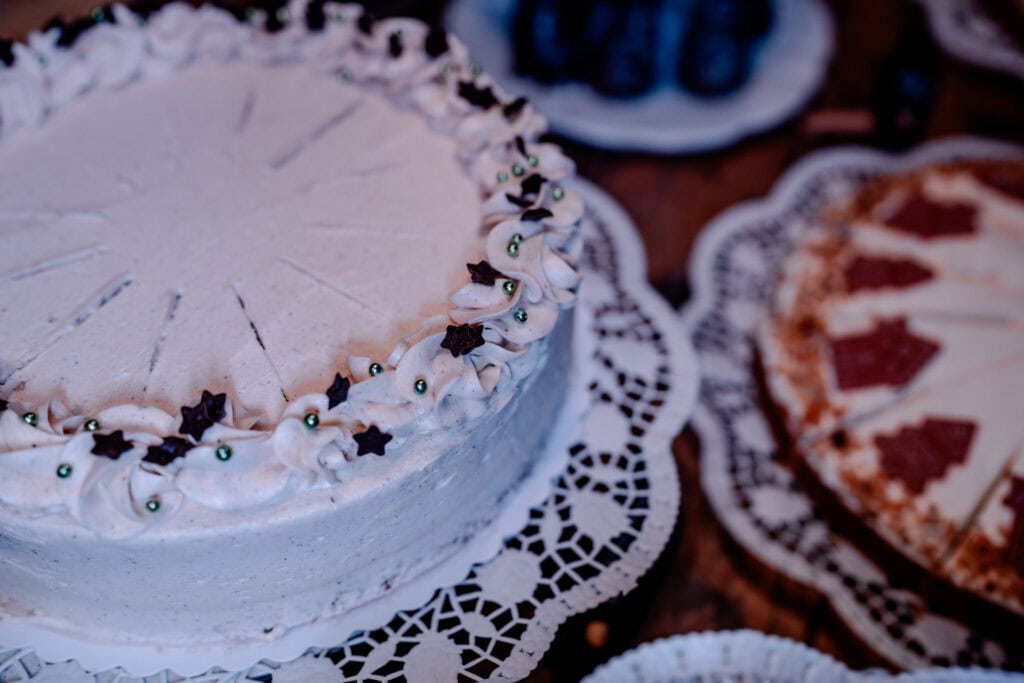 Leckere Torte mit weißer Glasur und Dekorationen auf einem festlichen Tisch.