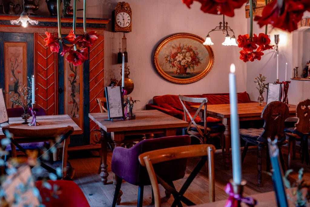 Gemütliches, liebevoll dekoriertes Wohnzimmer mit Blumen und Kerzen, rustikaler Stil.