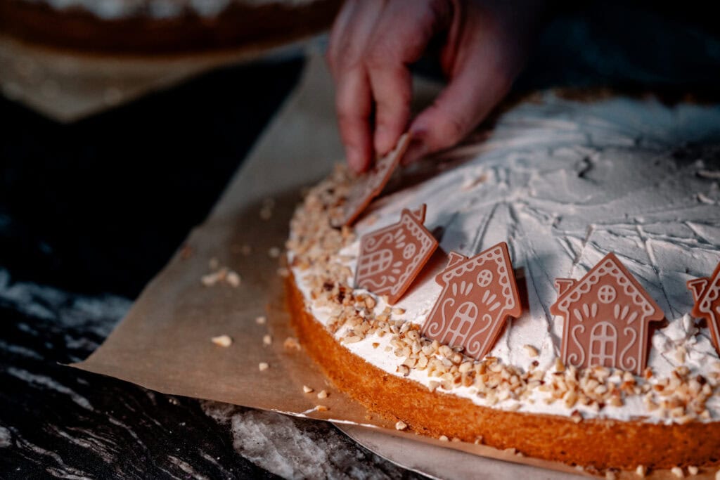 Backkunst mit Zuckerguss und Lebkuchenhäuser auf Weihnachtskuchen.