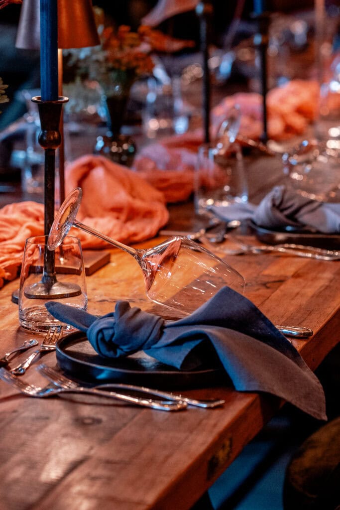 Eleganter gedeckter Tisch mit Kerzen, Gläsern und Stoffservietten bei Gut Leben Berlin.