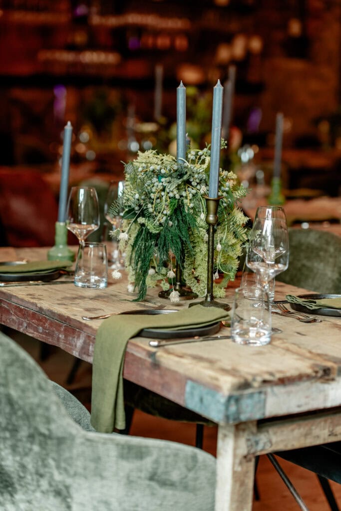 Eleganter gedeckter Tisch mit Kerzen und Blumen für festliche Veranstaltung bei Gut Leben.