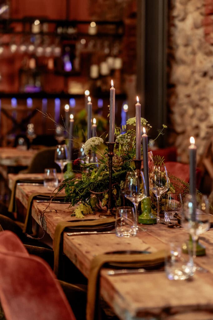 Eleganter gedeckter Tisch mit Kerzen und Blumen bei Gut Leben Berlin.