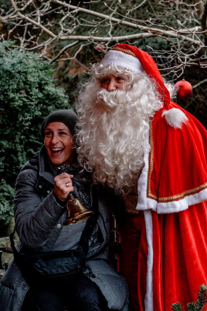 Frohe Weihnachtsstimmung mit Santa Claus und lachender Frau bei Gut Leben.